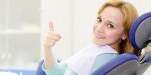 woman smiling in dental chair with thumb up Dr. Joe Thomas Dentistry