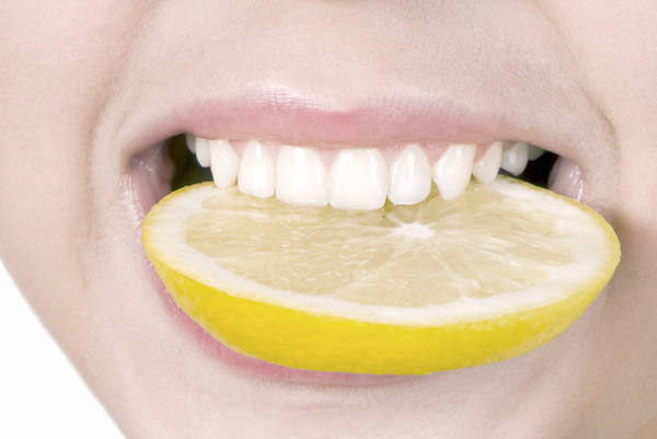 Smiling, biting lemon slice Dr. Joe Thomas Dentistry