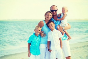 Family smiling on beach, family photo