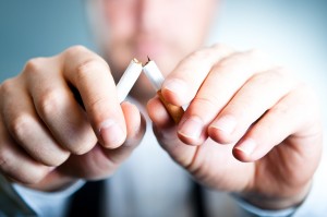 Breaking cigarette, man out of focus, quitting smoking Dr. Joe Thomas Dentistry